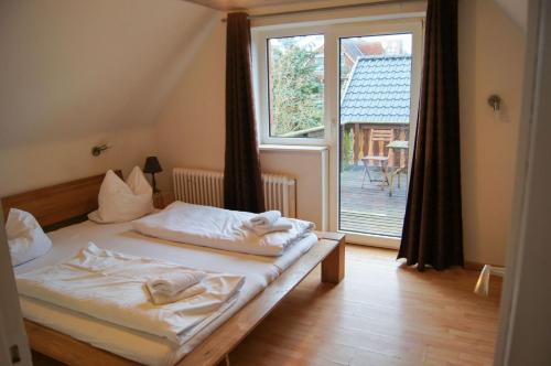 a bedroom with a bed and a large window at Nobis Krug in Groß Sarau