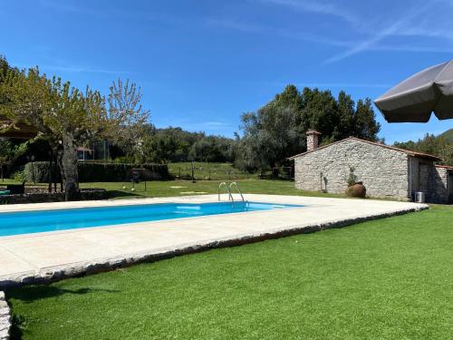 a swimming pool in a yard next to a house at Quinta das Eiras in Penela