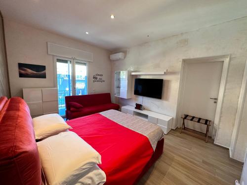 a bedroom with a red bed and a red couch at Othalan Home in Paestum