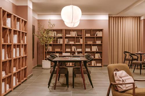 a library with a table and chairs and bookshelves at Sonder Arlo in Ottawa