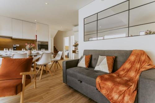 een woonkamer met een bank en een eetkamer bij Bruval Premium Apartments - Gaia in Vila Nova de Gaia