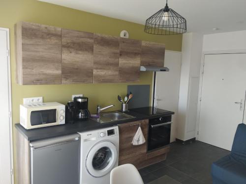 cocina con lavadora y microondas en L'Altéia - L'appartement les pieds dans l'eau avec place de parking privé et accès direct à la plage, en Berck-sur-Mer