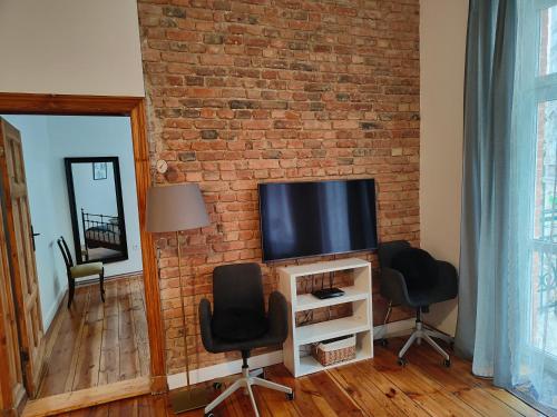 a living room with a tv on a brick wall at Prad 543 in Poznań