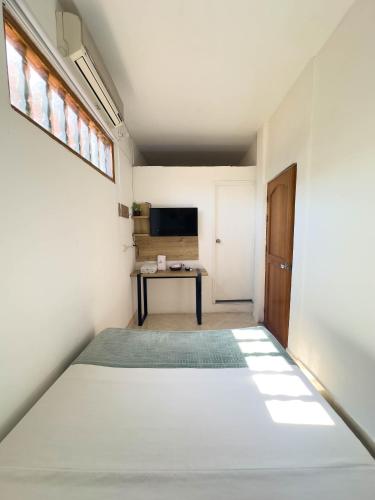 a bedroom with a bed and a desk in a room at Curazao Hotel -Centro Histórico- in Santa Fe de Antioquia