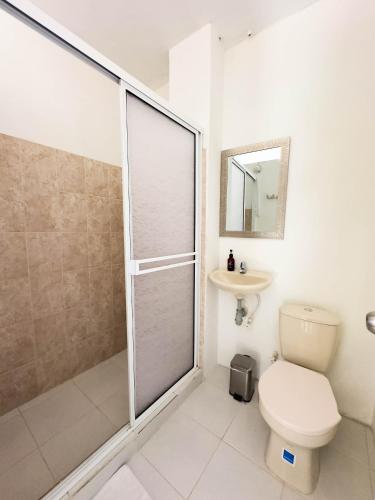 a bathroom with a shower and a toilet and a sink at Curazao Hotel -Centro Histórico- in Santa Fe de Antioquia