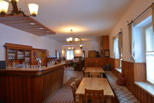 een restaurant met houten tafels en een bar bij Alpengasthof Gutenbrunn in Mallnitz