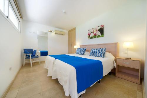 een slaapkamer met een blauw en wit bed met blauwe kussens bij La Cataleya in San Agustin