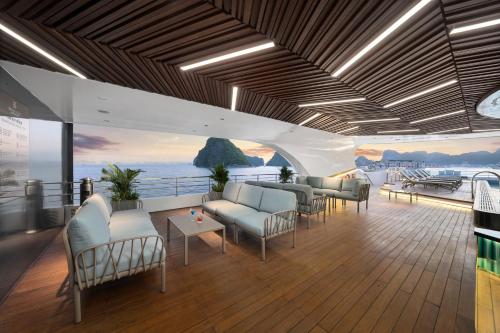 a room with chairs and tables and a view of the ocean at Grand Pioneers Halong Bay Cruise 1 in Ha Long