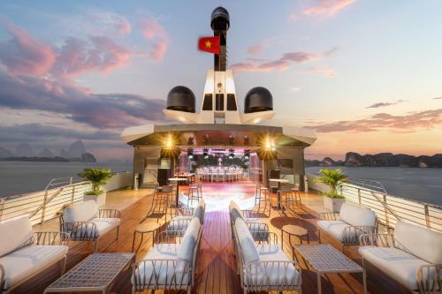 a deck on a cruise ship with chairs and a bar at Grand Pioneers Halong Bay Cruise 1 in Ha Long