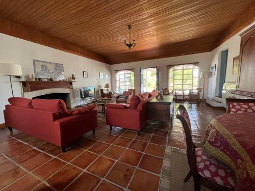 a living room with red furniture and a fireplace at Vale de Camelos Country House, Alentejo, Portugal. in Alcaria Ruiva