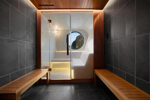 a bathroom with a shower and a glass door at Grand Pioneers Halong Bay Cruise 1 in Ha Long