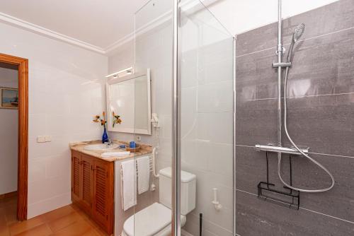 a bathroom with a shower and a toilet and a sink at Villa Vilar by Sealand Villas in El Port