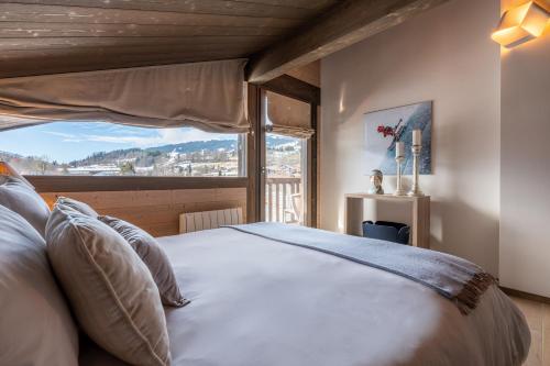 une chambre avec un grand lit avec une grande fenêtre dans l'établissement Chalet Satine - Luxe au pied des pistes, à Demi-Quartier