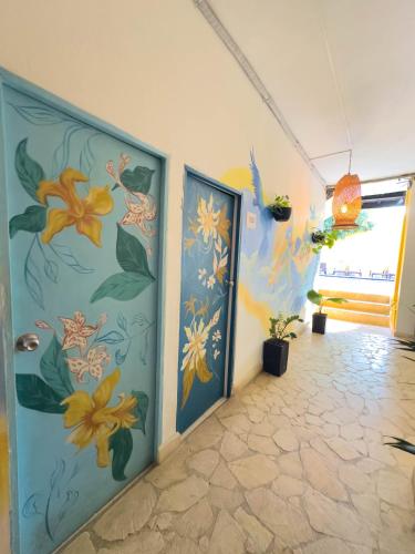 two doors in a room with flowers on the wall at Curazao Hotel -Centro Histórico- in Santa Fe de Antioquia