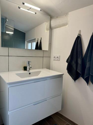 a bathroom with a white sink and a mirror at Maisonnette de village à Rasteau in Rasteau