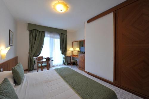 a hotel room with a bed and a large sliding door at Grand Hotel Cesare Augusto in Sorrento
