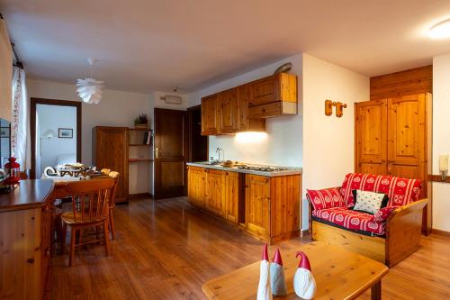 eine Küche und ein Wohnzimmer mit einem Sofa und einem Tisch in der Unterkunft Residence Cima Jazzi in Macugnaga