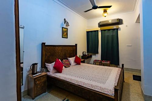 a bedroom with a bed with red pillows at Matra Chaya in Jodhpur