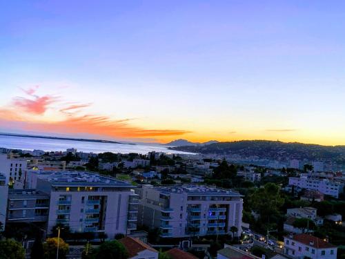 - une vue sur la ville au coucher du soleil dans l'établissement T3 75m² Incroyable Vue Mer/Piscine/Tennis/Terrasse, à Antibes