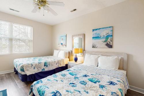 een slaapkamer met 2 bedden en een plafondventilator bij Seaside Unit C in Myrtle Beach