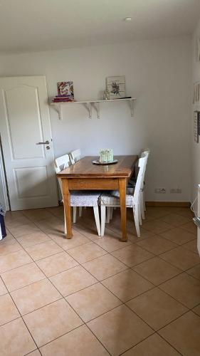 a dining room with a wooden table and white chairs at Gästehaus Bönebüttel-nahe Neumünster Netflix in Bönebüttel