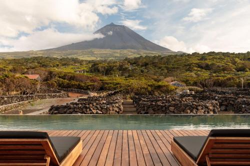 a pool with a mountain in the background at Adega do Fogo in São Roque do Pico