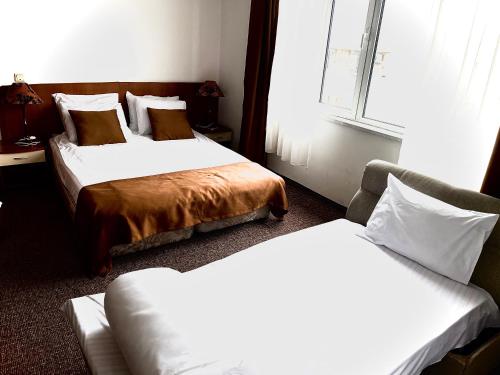 a hotel room with two beds and a window at Slavyanska Beseda Hotel in Sofia
