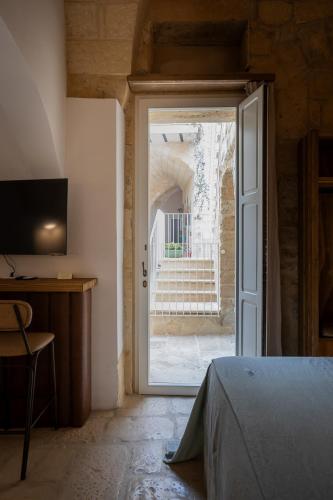 a bedroom with a door open to a courtyard at Palazzo Sant'Anna Lecce in Lecce
