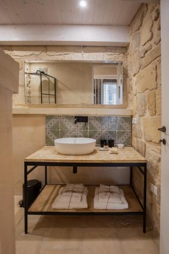 a bathroom with a sink and a counter with towels at Palazzo Sant'Anna Lecce in Lecce