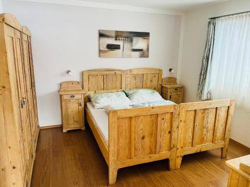 a bedroom with a wooden bed and wooden cabinets at Ferienwohnung Martina in Schlitters