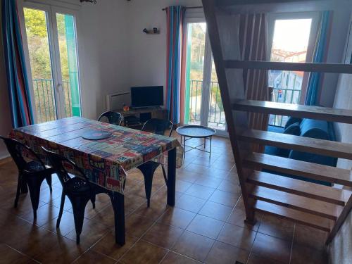 un salon avec une table, des chaises et des fenêtres dans l'établissement 4MIR11BLEU - Appartement pour 4 personnes T2 en duplex tout confort, à Collioure