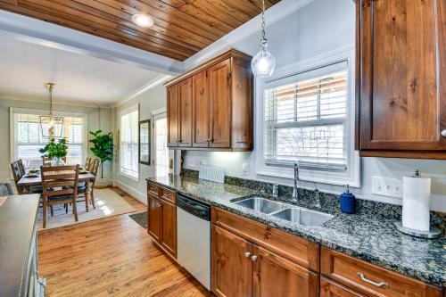a kitchen with wooden cabinets and a dining room at Lakefront Jacksons Gap Retreat with Grill and Dock! in Jacksons Gap