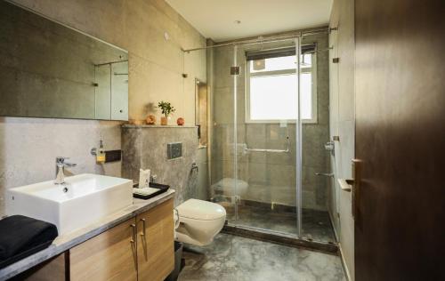 a bathroom with a shower and a sink and a toilet at KRYC Luxury Living in New Delhi