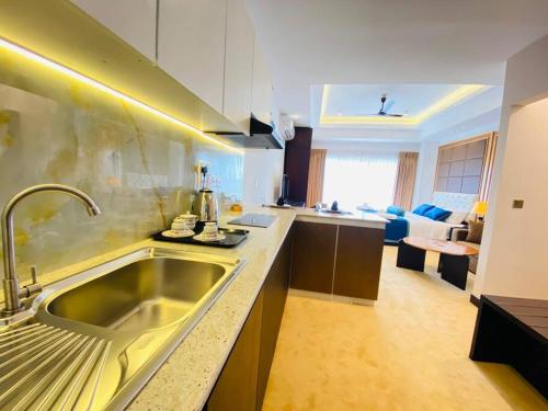 a kitchen with a sink and a living room at Fun-Ocean-Chill in Negombo