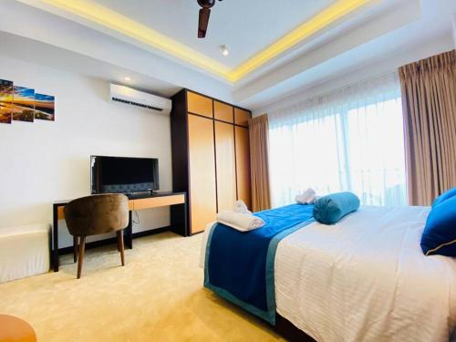 um quarto com uma cama, uma secretária e uma televisão em Fun-Ocean-Chill em Negombo