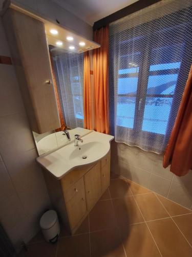 baño con lavabo, espejo y ventana en Schütterhof, en Ramsau am Dachstein