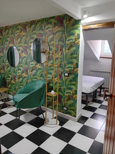 a room with a green chair and a checkerboard floor at bijou loft in La Spezia