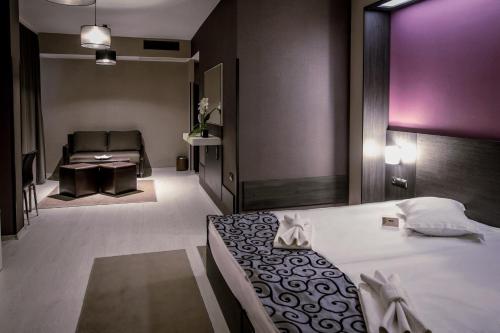 a bedroom with a bed and a chair and a couch at Hotel Idol in Targovishte