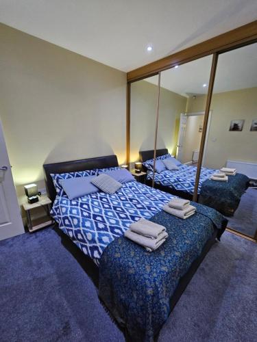1 dormitorio con 2 camas y un espejo grande en Atlantic Views ground floor apartment en Portrush