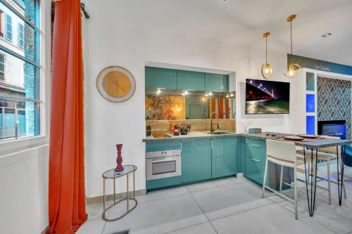 une cuisine avec des armoires bleues et une table dans l'établissement Aphrodite suite de prestige, à Dijon