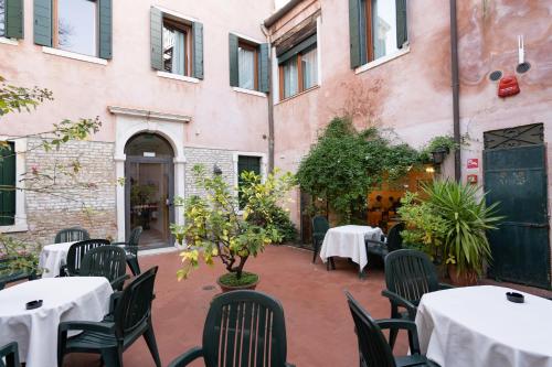 an outdoor patio with tables and chairs in a restaurant at Hotel Tivoli in Venice