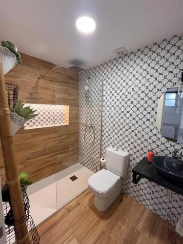 a bathroom with a toilet and a shower and a sink at Estudio Bolingas in Comillas