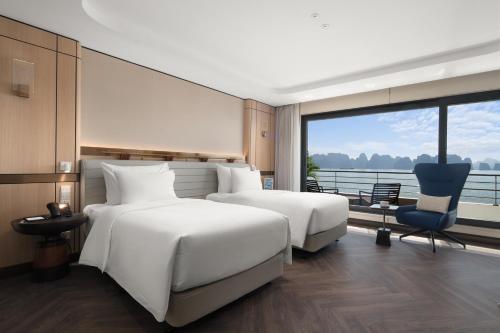 two beds in a hotel room with a view at Grand Pioneers Halong Bay Cruise 1 in Ha Long