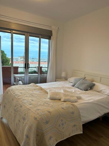a bedroom with a large bed with a large window at Frente al puerto y junto a la playa del Arenal in Burriana