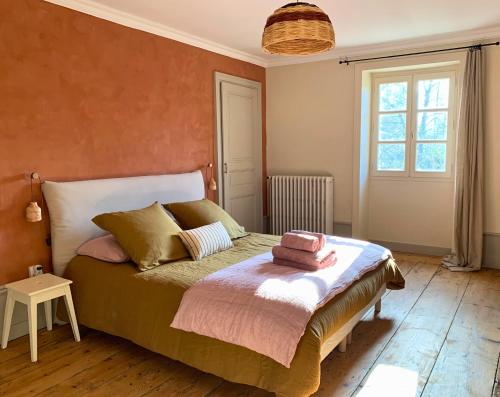 a bedroom with a bed with two towels on it at Maison d'hôtes et gîte de charme avec piscine, La Lhuiseraie in Lhuis