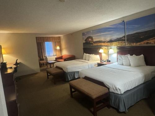 a hotel room with two beds and a large painting on the wall at Days Inn by Wyndham Sturgis in Sturgis