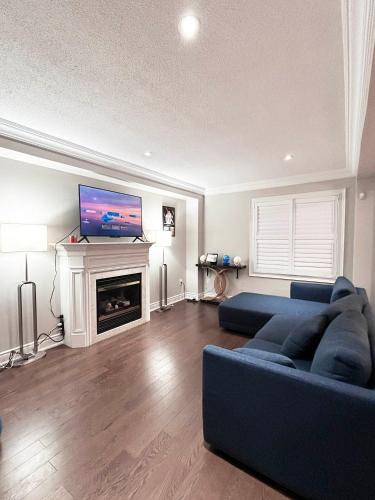 a living room with a blue couch and a fireplace at A Room in Oshawa, Free Parking in Oshawa