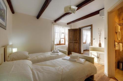 a bedroom with two beds and a mirror at Villa Moncalvo in Bale