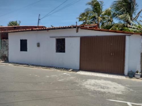 um edifício branco com uma garagem castanha e branca em Casa Village Praia em Almfala