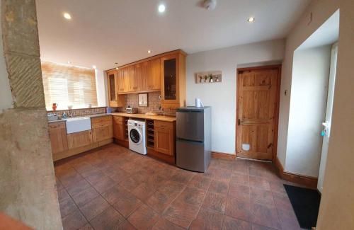 a large kitchen with wooden cabinets and a dishwasher at The Old Poets' Corner in Chesterfield